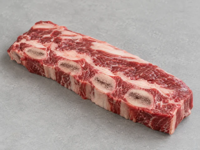 牛仔骨辨認示意：橫切肉排排列多個骨眼；紅肉夾白色脂紋；扁條肉排有硬肋骨截面。