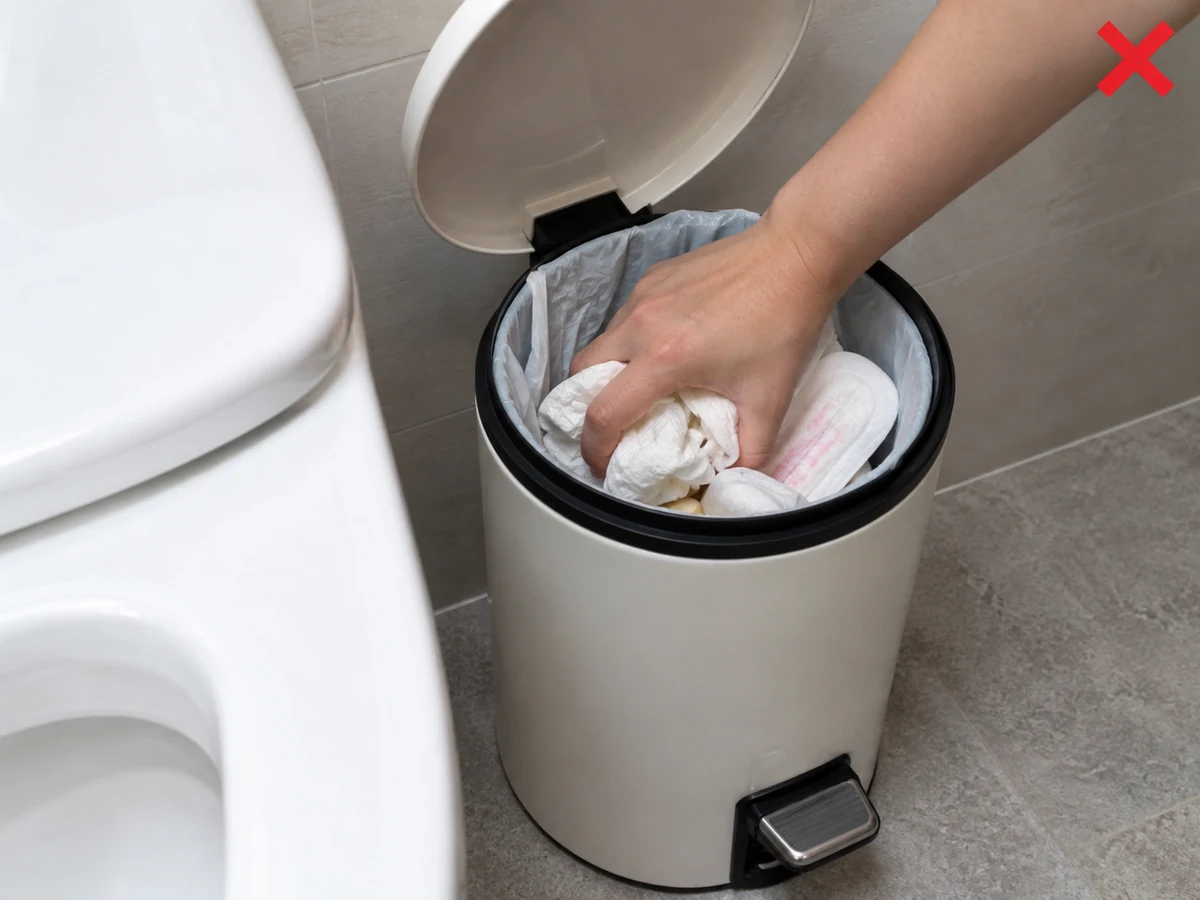 Memadatkan sampah dengan tangan — Jangan memadatkan; pakai sarung tangan dan tutup liner dengan lembut.