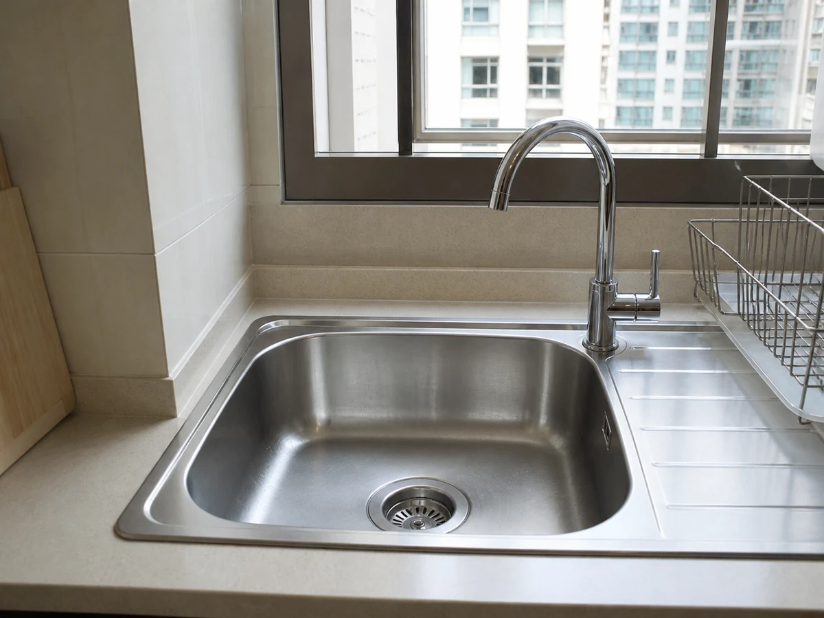 How to Clean a Kitchen Sink and Reduce Odour: Check drainage and report faults