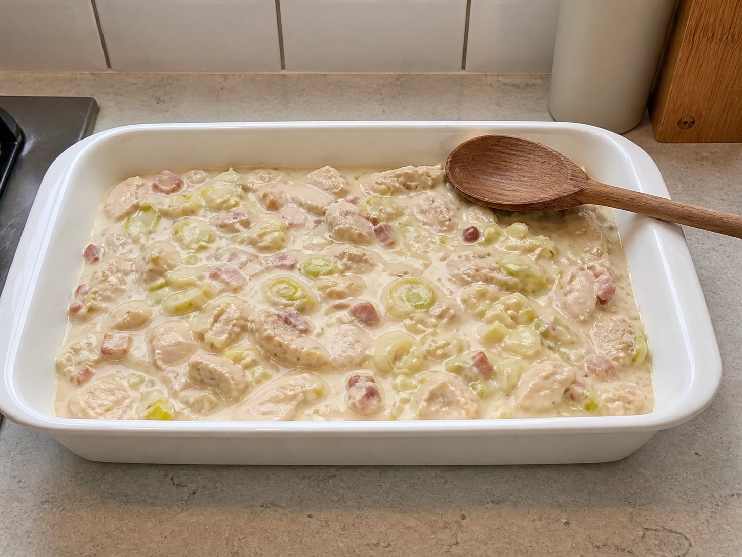 Ratakan isian ayam panas di loyang: Ratakan isian ayam panas di loyang. Kerjakan dengan hati-hati, pertahankan panas, waktu, dan keadaan bahan yang disebutkan, lalu pastikan kematangan sebelum melanjutkan.