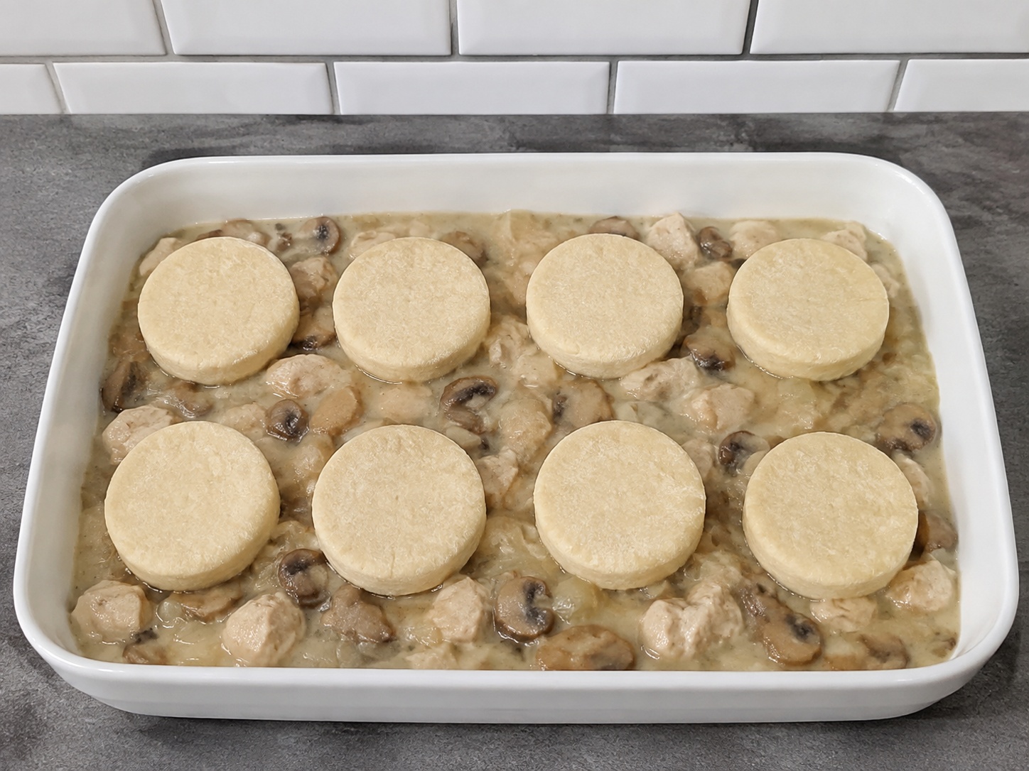 Cobbler Suet Ayam dan Jamur Inggris — Susun topping: Letakkan bulatan terpisah di atas isian.