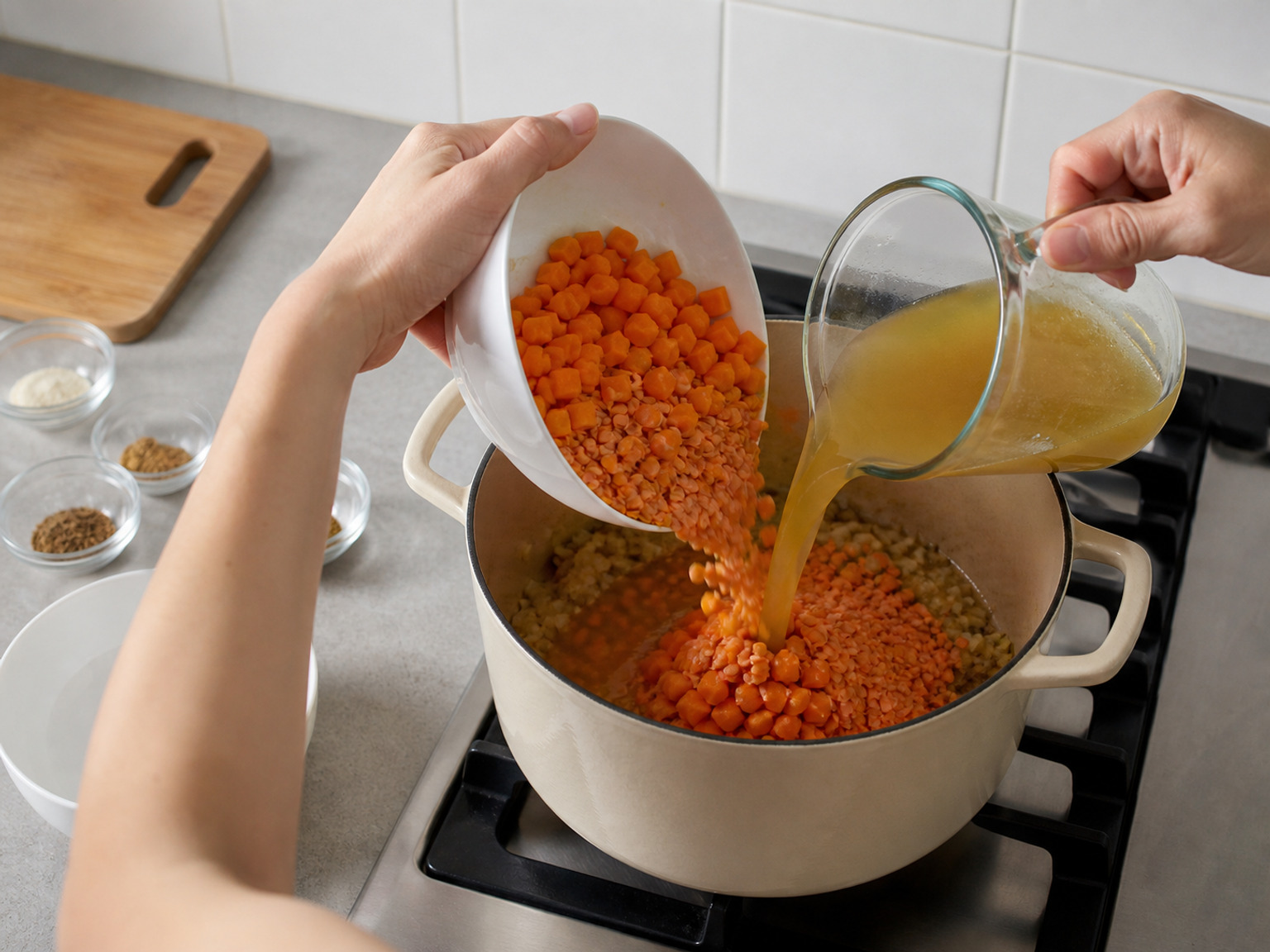 Add carrots, lentils and stock: Add all 700 g carrots and 220 g lentils, pour in all 1.2 litres vegetable stock, and scrape the pot bottom clean.
