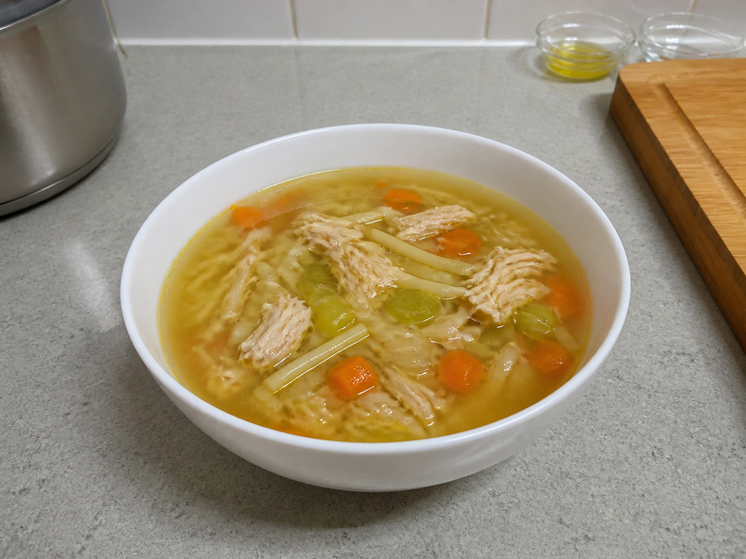 檢查蔬菜後上碟: 試吃一粒甘筍確認軟熟，再把雞肉、意粉、蔬菜及清湯平均分入 6 個碗。