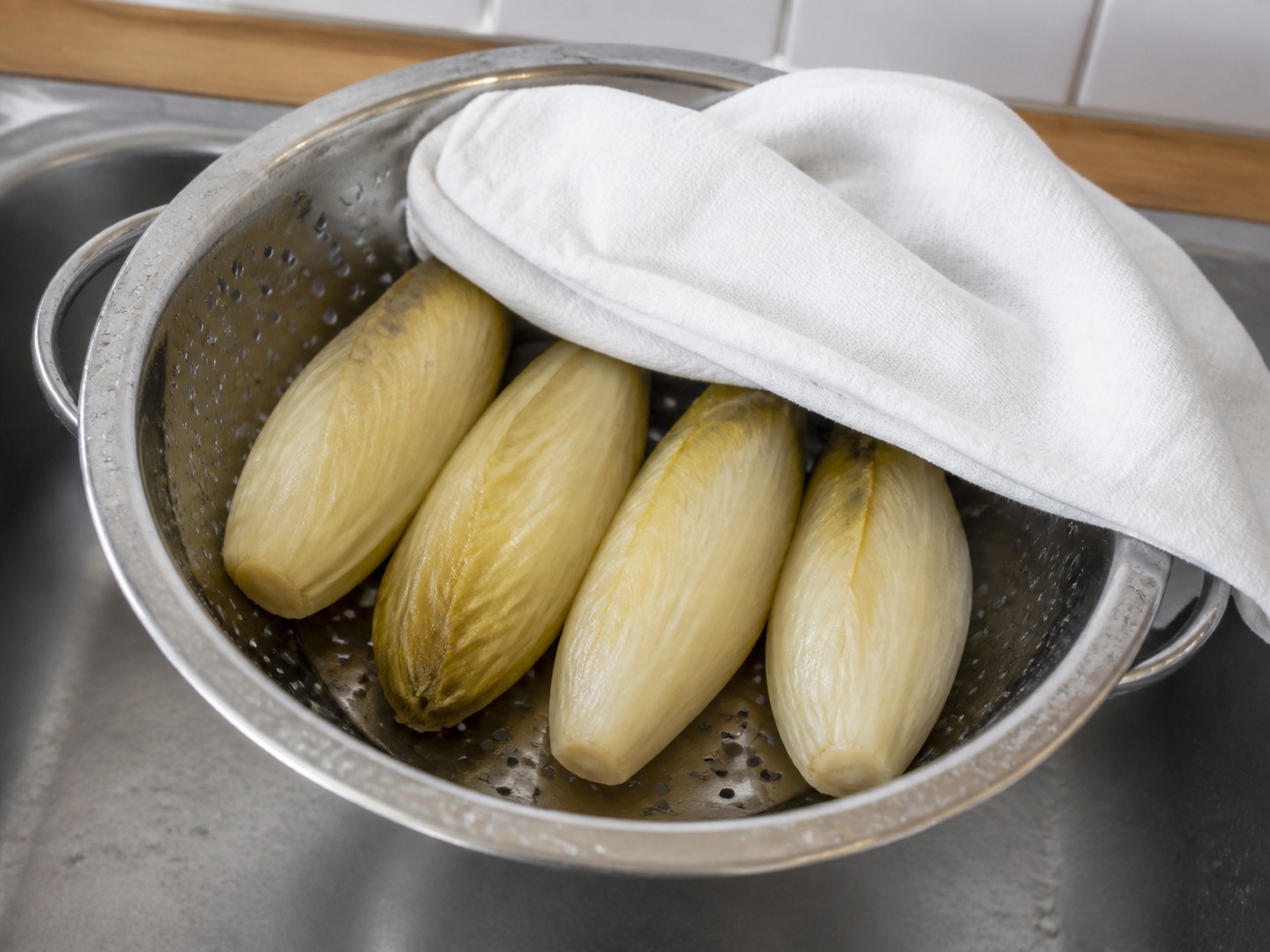Gratin Endive dan Ham Prancis — Tiriskan dan tekan kering: Tiriskan dan dinginkan endive lalu tekan perlahan agar air keluar.
