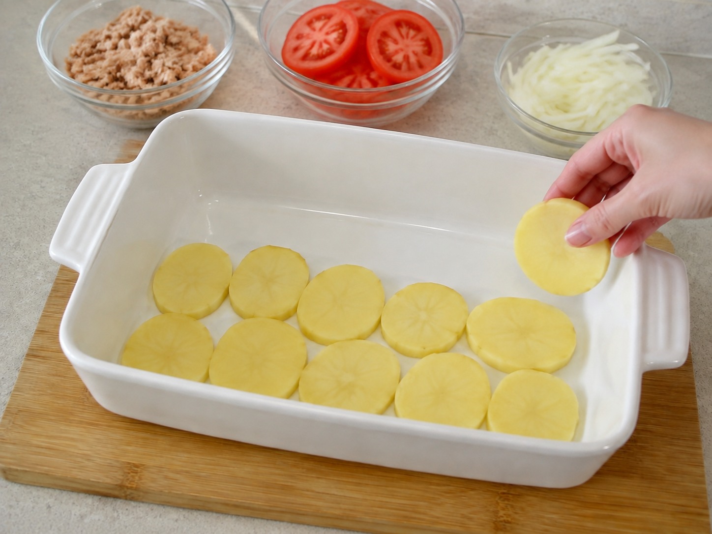 French Tuna, Potato at Tomato Gratin — Ayusin ang kalahating patatas sa pantay na sapin.