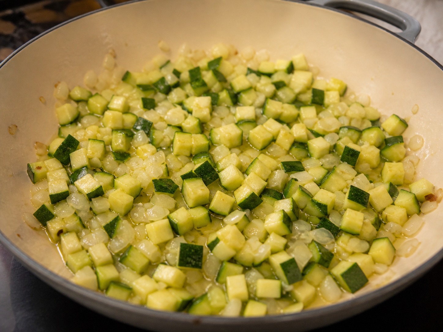 Greek Baked Tomato and Feta Orzo, step 5, Cook the zucchini until lightly golden: Add all the diced zucchini and cook over medium-high heat for 4 minutes, stirring once, until a few edges are pale gold but the cubes remain firm.