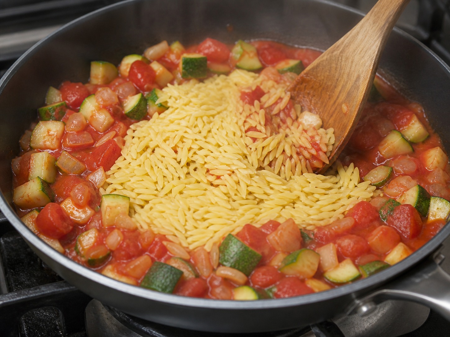 Greek Baked Tomato and Feta Orzo, step 7, Coat the dry orzo in the sauce: Add all 350 g dry orzo and fold for about 30 seconds until every grain-shaped piece is coated in tomato sauce.