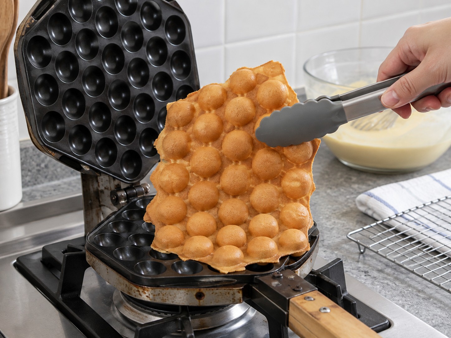 Hong Kong Egg Waffles — 11. Open the pan and lift the fully set waffle with heatproof tongs.