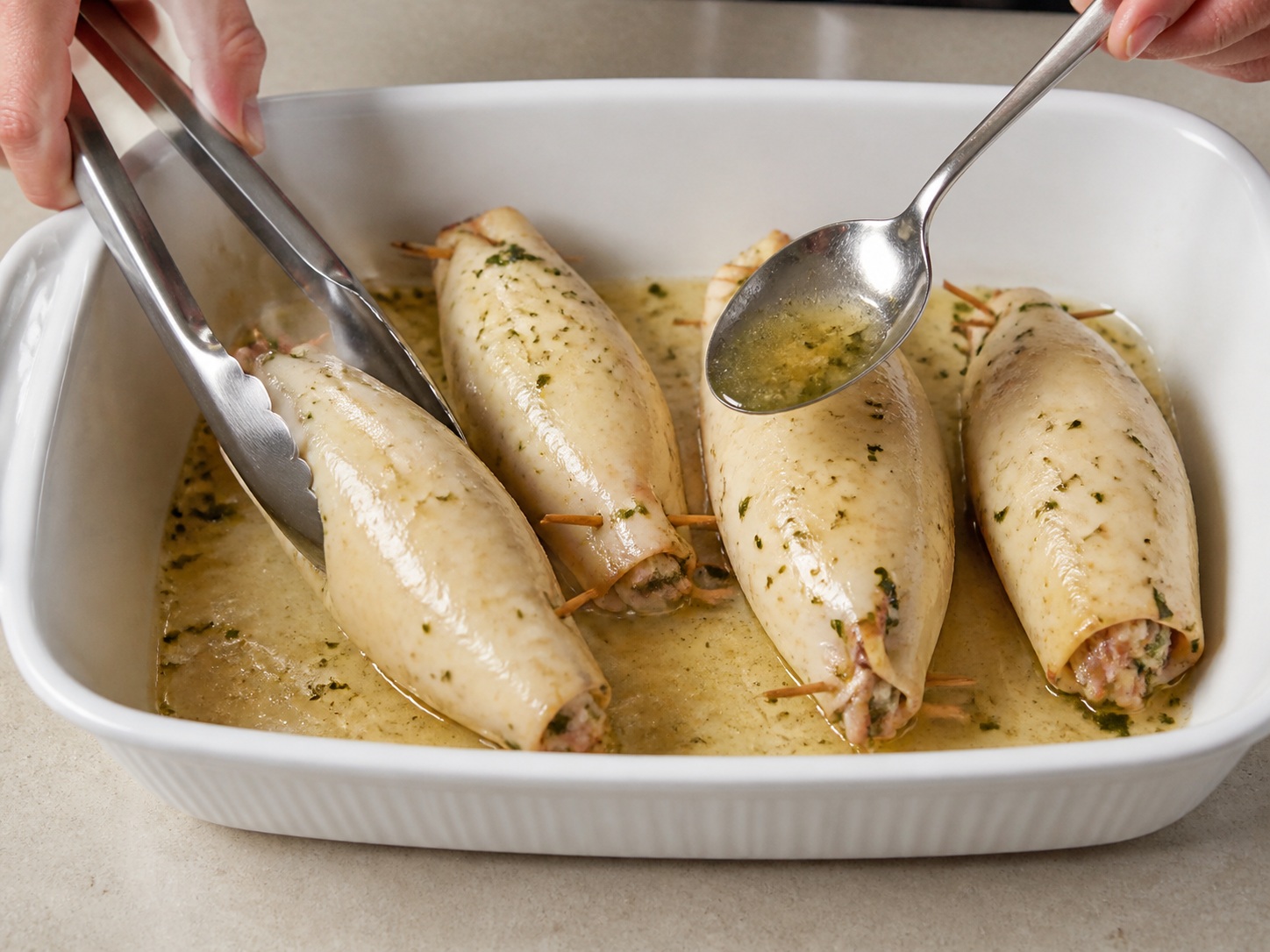 Italyanong Inihurnong Pusit na Pinalamanan ng Herba at Breadcrumbs — Baligtarin at baste: Baligtarin ang squid at baste gamit ang katas sa dish.