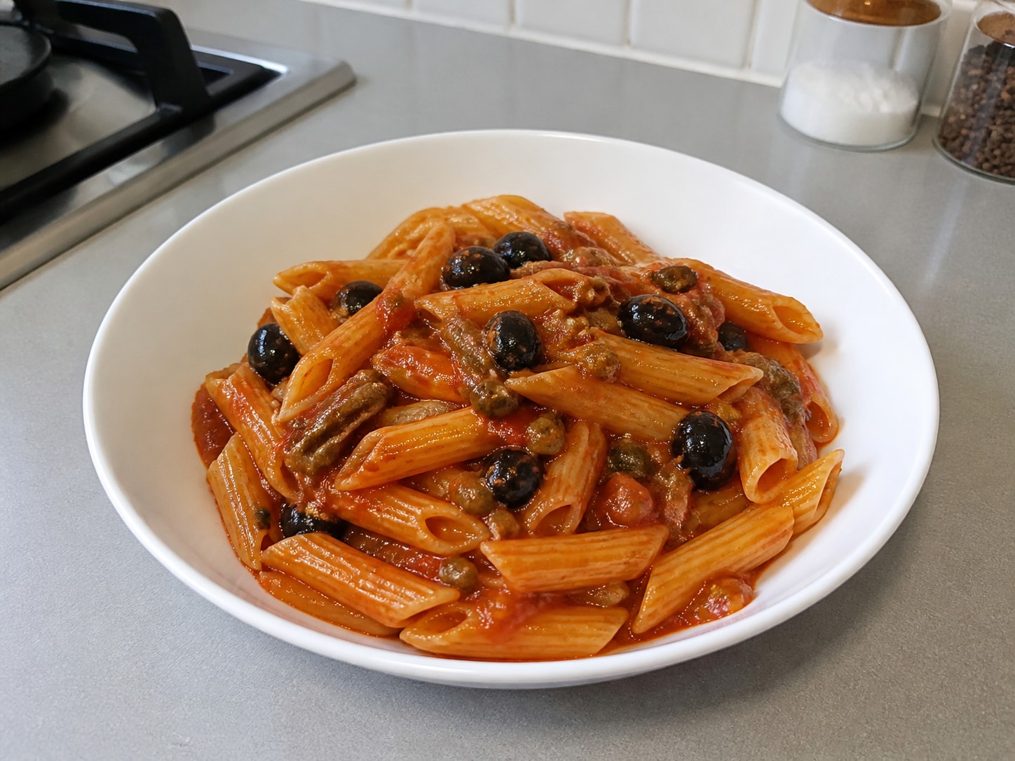 Italian Penne Puttanesca, step 12, Taste and serve immediately: Taste one piece, add no extra salt unless needed because the anchovies, olives and capers are salty, then divide among 4 warm bowls and serve hot.