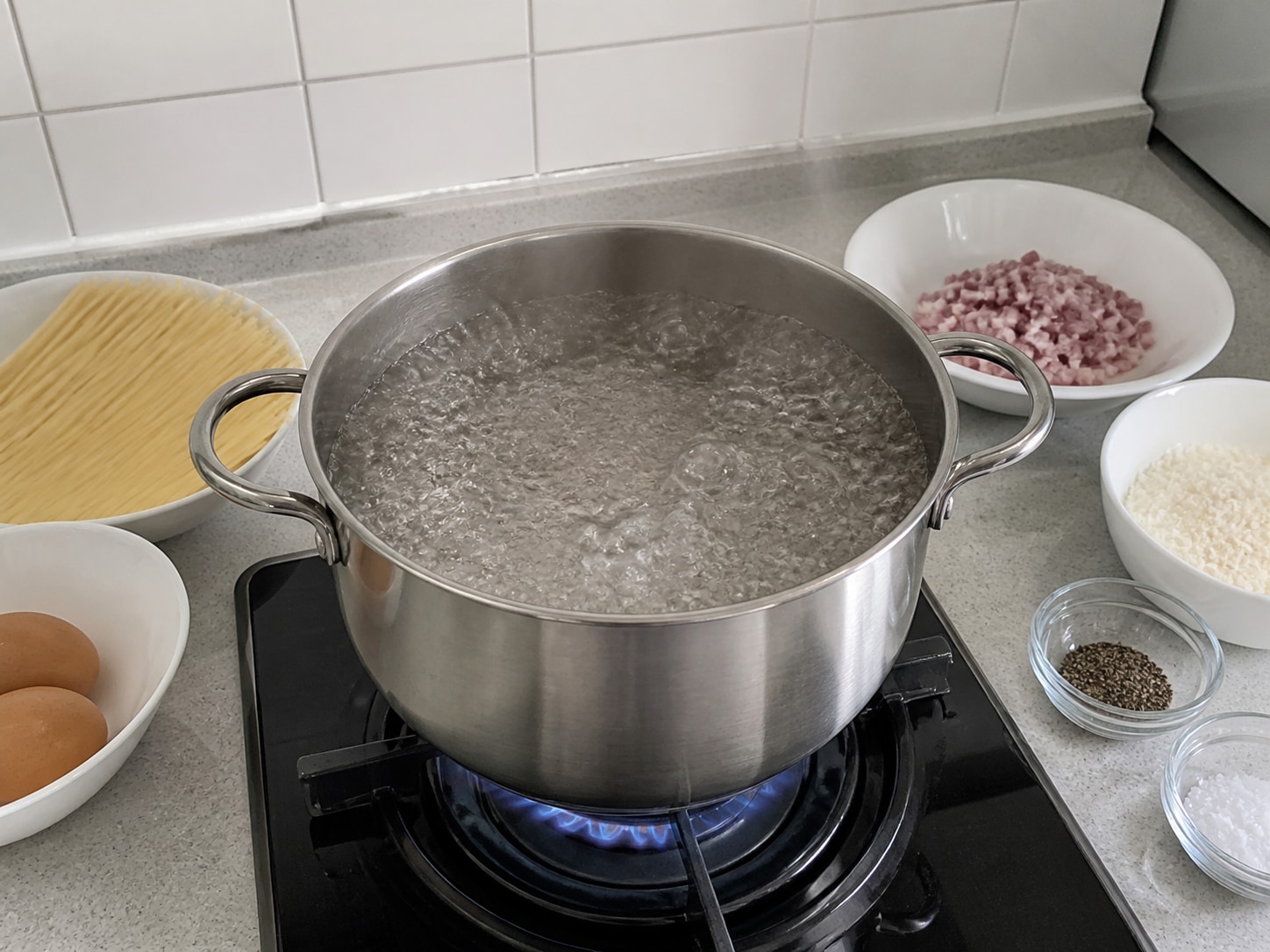 意式卡邦尼意粉第1步「煮滾鹽水」:在大鍋清水加入 1 茶匙鹽,以大火煮至持續翻滾。