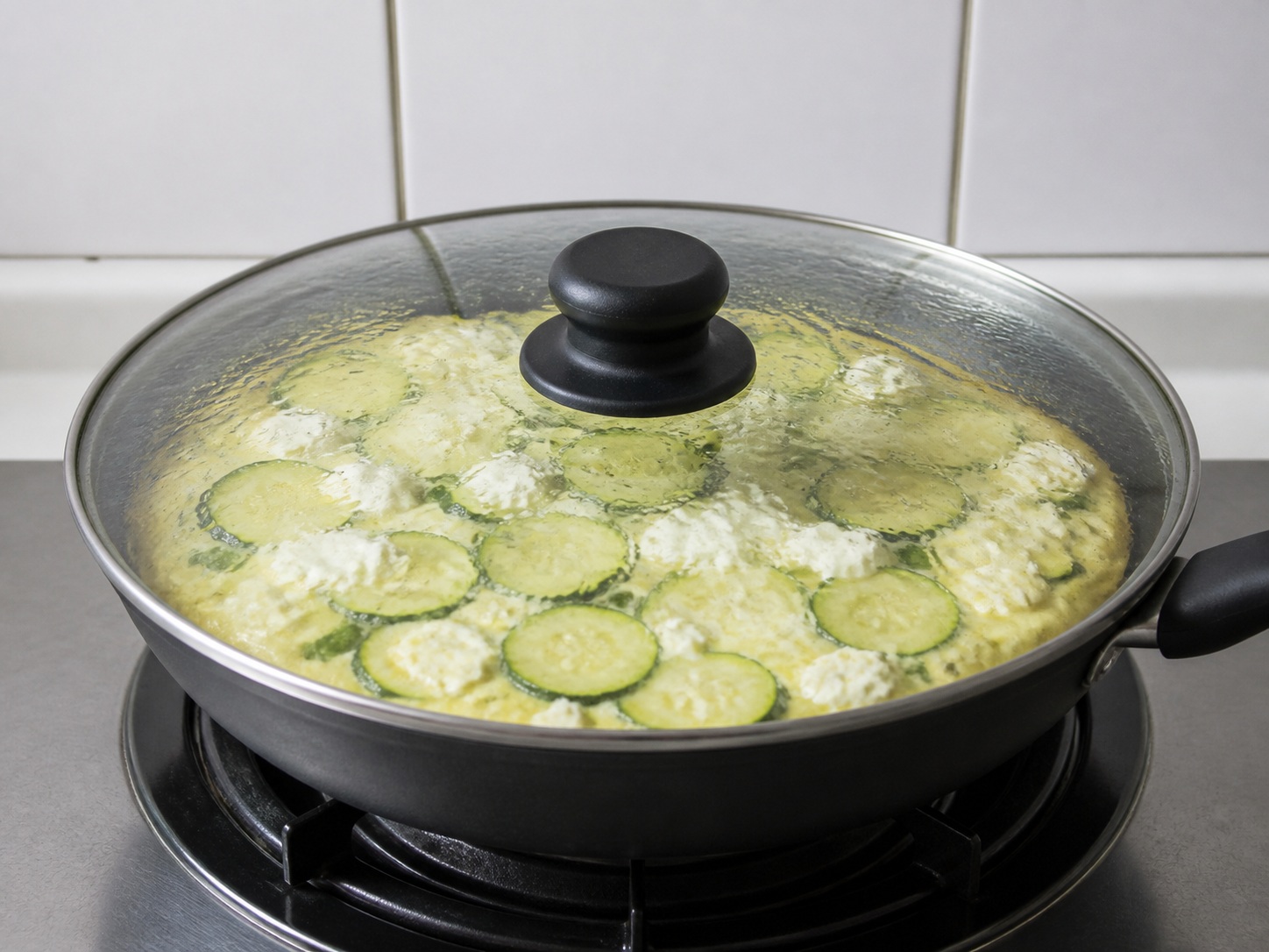 Italyanong Frittata na may Zucchini at Ricotta — Takpan at lutuin nang marahan: Takpan, hinaan ang apoy at lutuin nang 8 minuto upang marahang mag-set ang gitna.