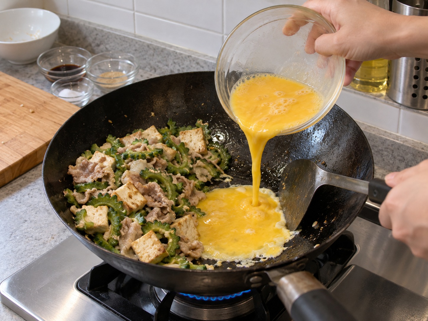 沖繩苦瓜豆腐豬肉炒蛋 — 把材料推到一邊，倒入蛋液