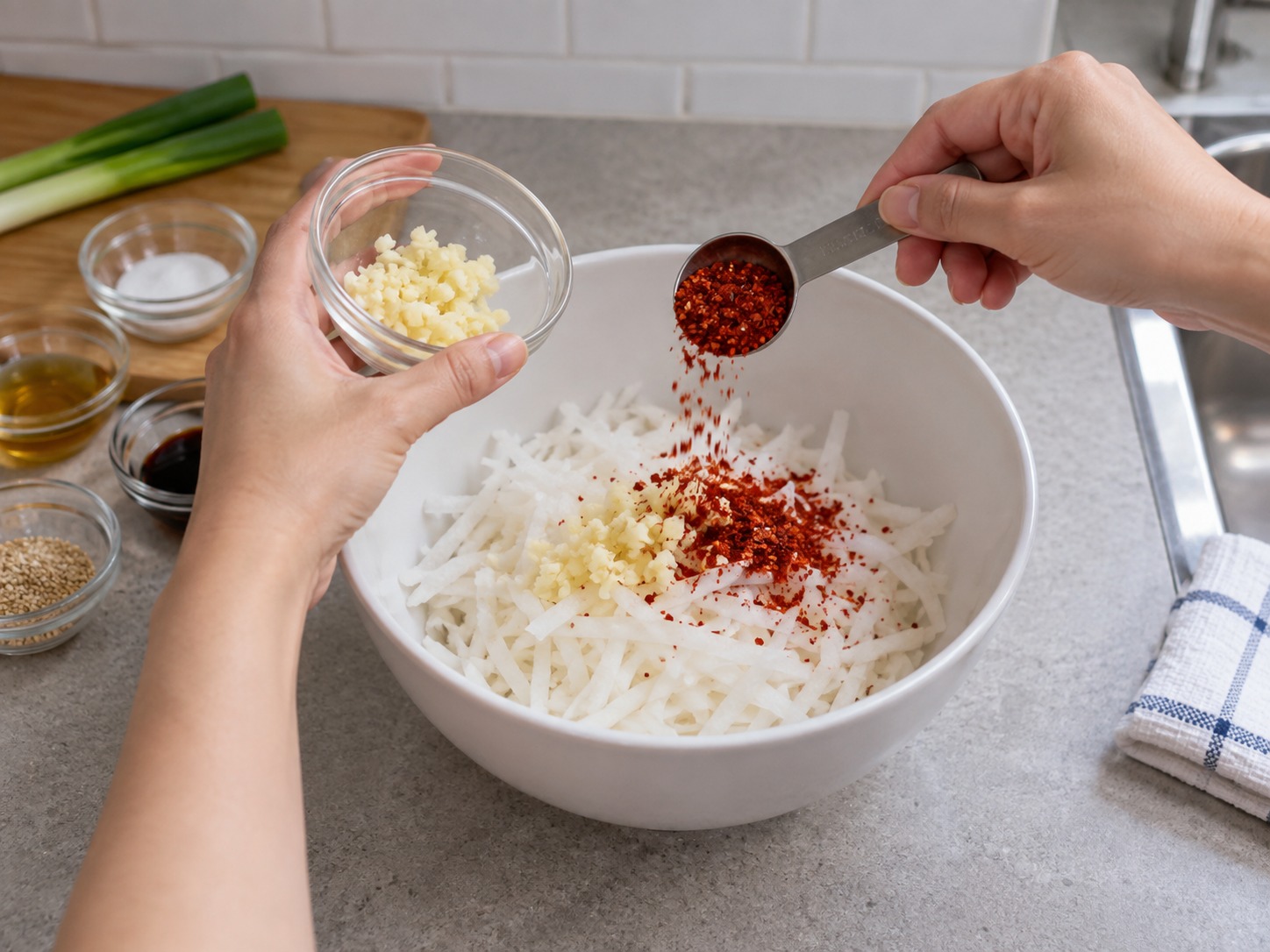 Korean Seasoned Radish Salad — Return daikon to a clean bowl and add garlic and Korean chilli flakes