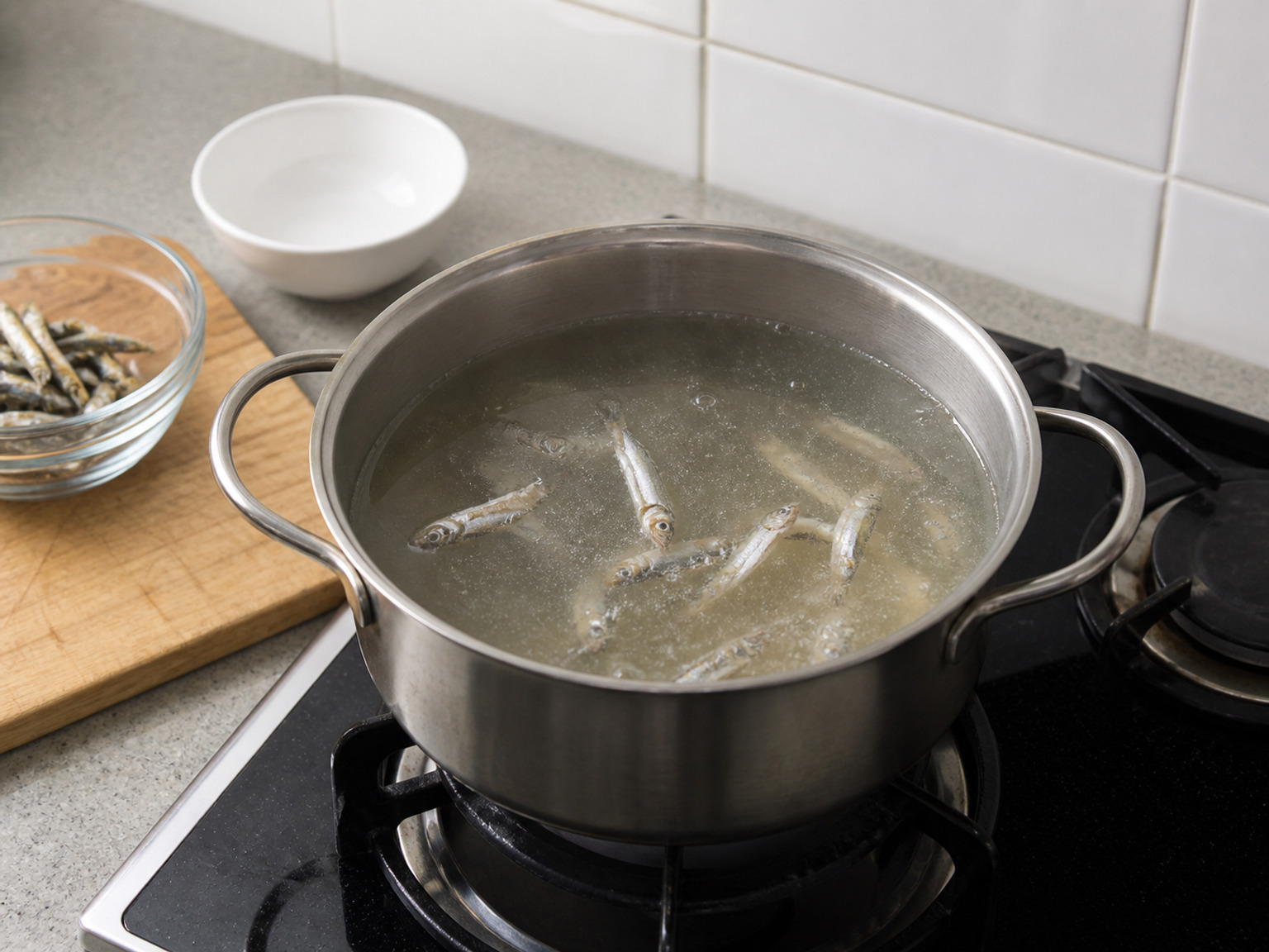 用乾鯷魚煮湯底: 小鍋加入乾魚仔和900毫升水，煮滾後轉小火煮10分鐘，湯呈淡金色即可。