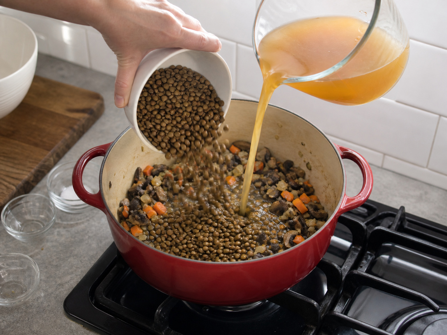 加入扁豆和菜湯: 加入全部已沖洗扁豆並倒入全部 800 毫升菜湯，刮淨鑊底後煮至微滾。