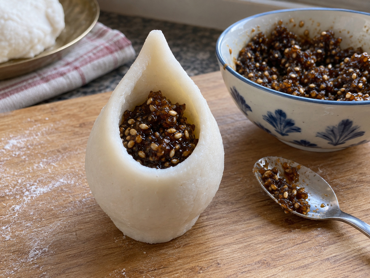 Nepali Yomari — Add about one spoonful of jaggery-sesame filling without overpacking