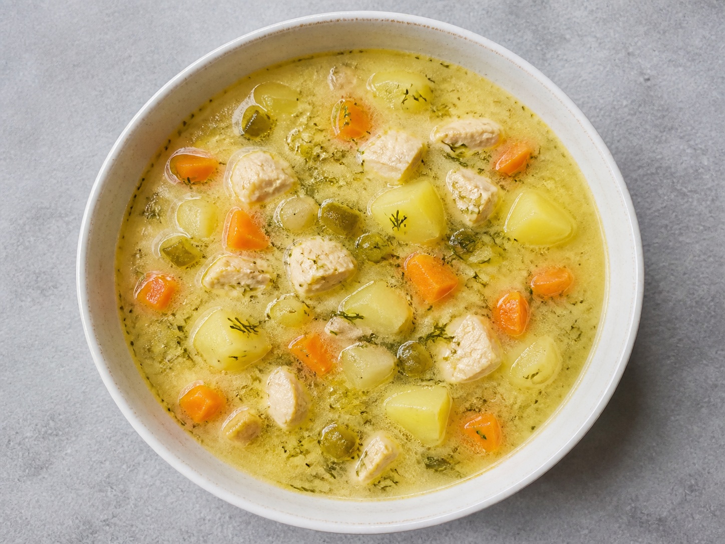 Polish Dill Pickle Chicken Soup: Chicken, potato and carrot are simmered in savoury broth sharpened with chopped dill pickles and pickle brine.