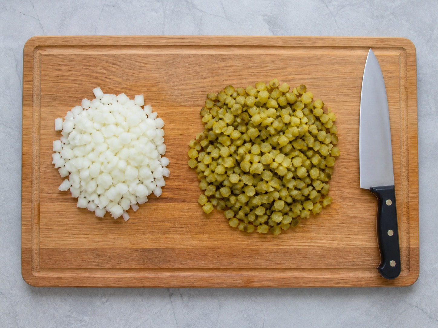 Potong dadu bawang dan acar: Potong dadu bawang dan acar. Gunakan bahan yang tercantum dan alat rumah tangga yang sesuai secara berurutan; pastikan kondisi bahan sesuai tahap ini sebelum lanjut.
