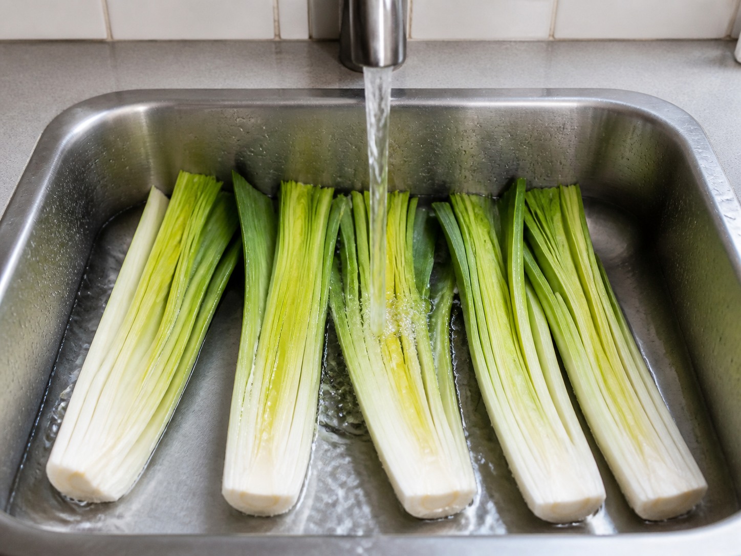 Belah daun bawang prei dan cuci di antara setiap lapisan: Belah daun bawang prei dan cuci di antara setiap lapisan. Kerjakan dengan hati-hati, pertahankan panas, waktu, dan keadaan bahan yang disebutkan, lalu pastikan kematangan sebelum melanjutkan.