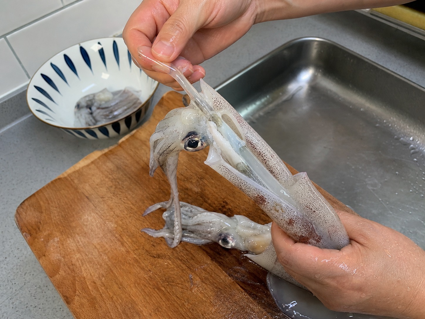 荷蘭豆炒鮮魷:把魷魚筒切開攤平,在內側斜切交叉花紋,再切成件。