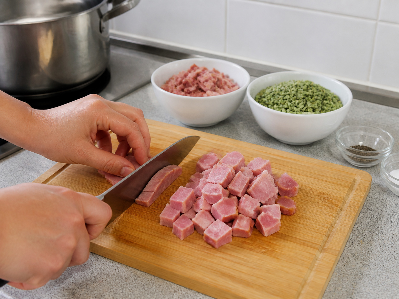 Potong ham menjadi dadu: Potong seluruh 300 g ham menjadi dadu rata 1 cm agar tiap sendok sup berisi potongan kecil yang cepat panas.