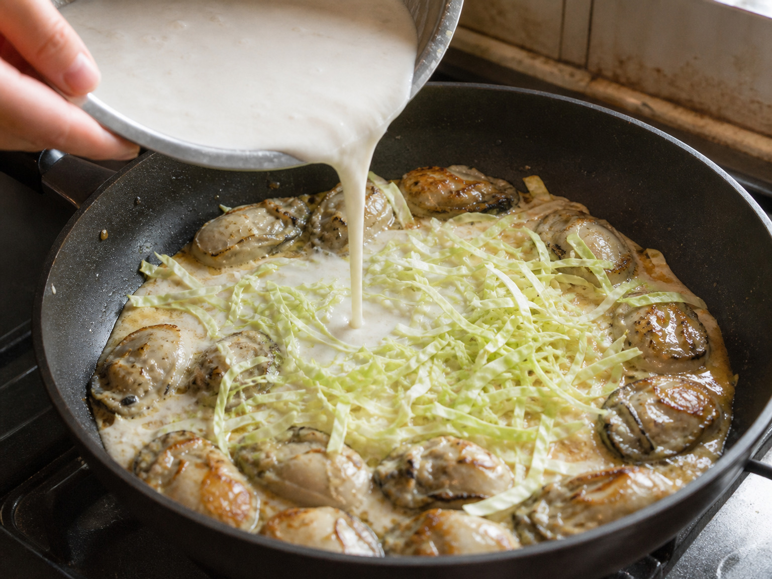 Ibuhos ang malabnaw na gawgaw na patatas at idagdag ang repolyo: Haluing muli ang malabnaw na gawgaw na patatas, ibuhos nang pantay sa palibot ng talaba, saka ikalat ang buong repolyo. Lutuin sa katamtamang apoy nang 90 segundo hanggang luminaw at magsimulang mamuo ang gilid.